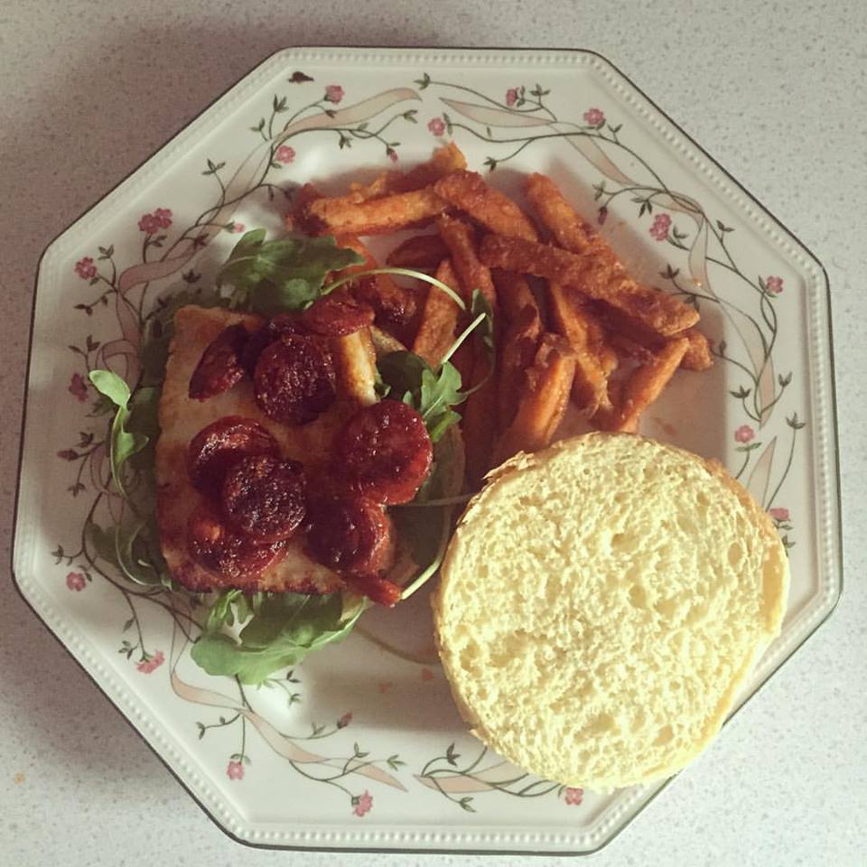 A Chorizo & Halloumi Burger, with rocket salad and a side of sweet potato fries.
