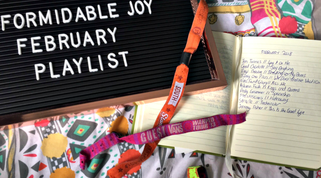 My The February Playlist written out in a notebook, featuring songs from Ten Tonnes, Good Charlotte and more. Beside the notebook is a letter board, with the words 'Formidable Joy February Playlist' on it. Two festival wristbands lay over the two.